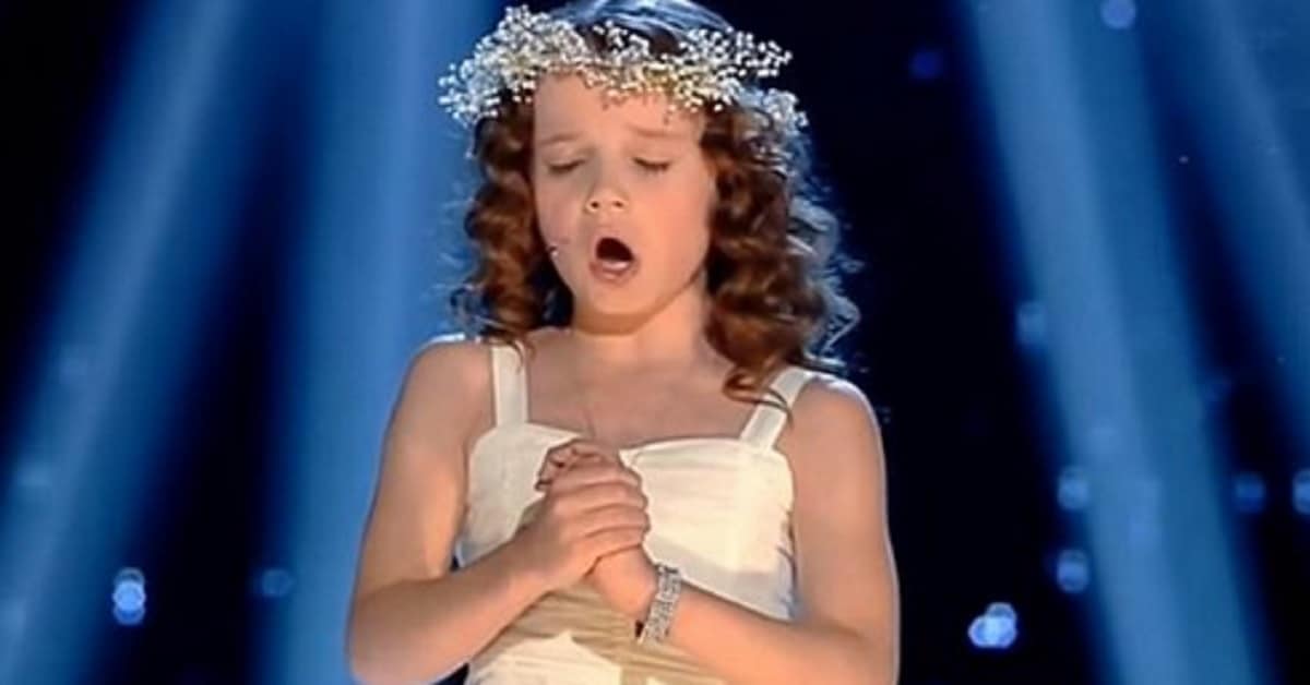 Voce angelica, riccioli d’oro e corona di fiore, a soli 9 anni canta l’Ave Maria e meraviglia tutti per il talento.