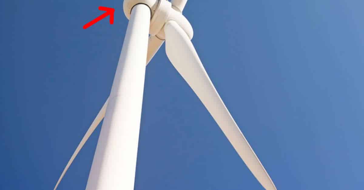 Un drone cattura un monaco che prende il sole sopra una turbina eolica